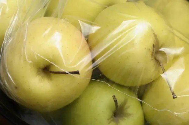 Яблоки в полиэтиленовых пакетах в погребе